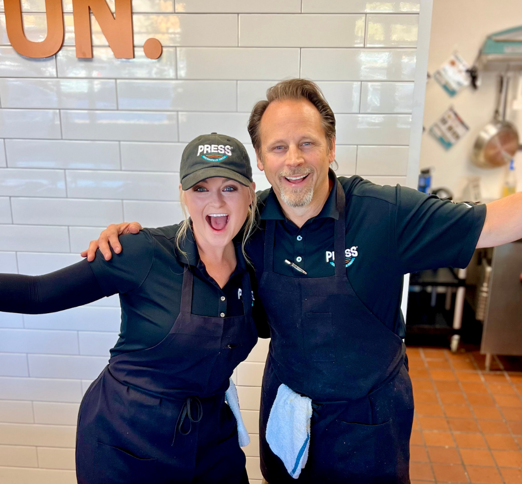 Two people in a Press restaurant expressing joy