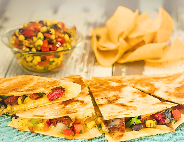 Quesadilla next to salsa and chips.